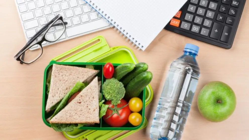 Office desk with supplies and lunch box
